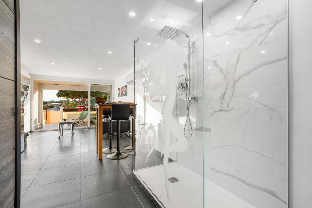 une cabine de douche en verre dans une pièce avec un bureau dans l'établissement Village Naturiste R4N - Le FrenchK-iss Port Nature, au Cap d'Agde