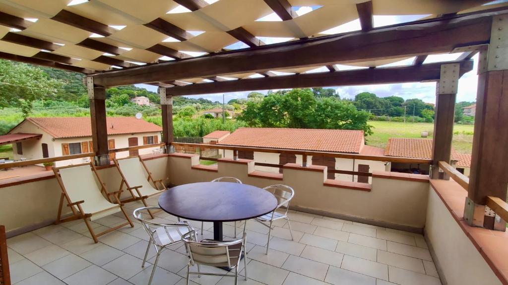 a patio with a table and chairs on a balcony at Podere Il Ritorno in Portoferraio