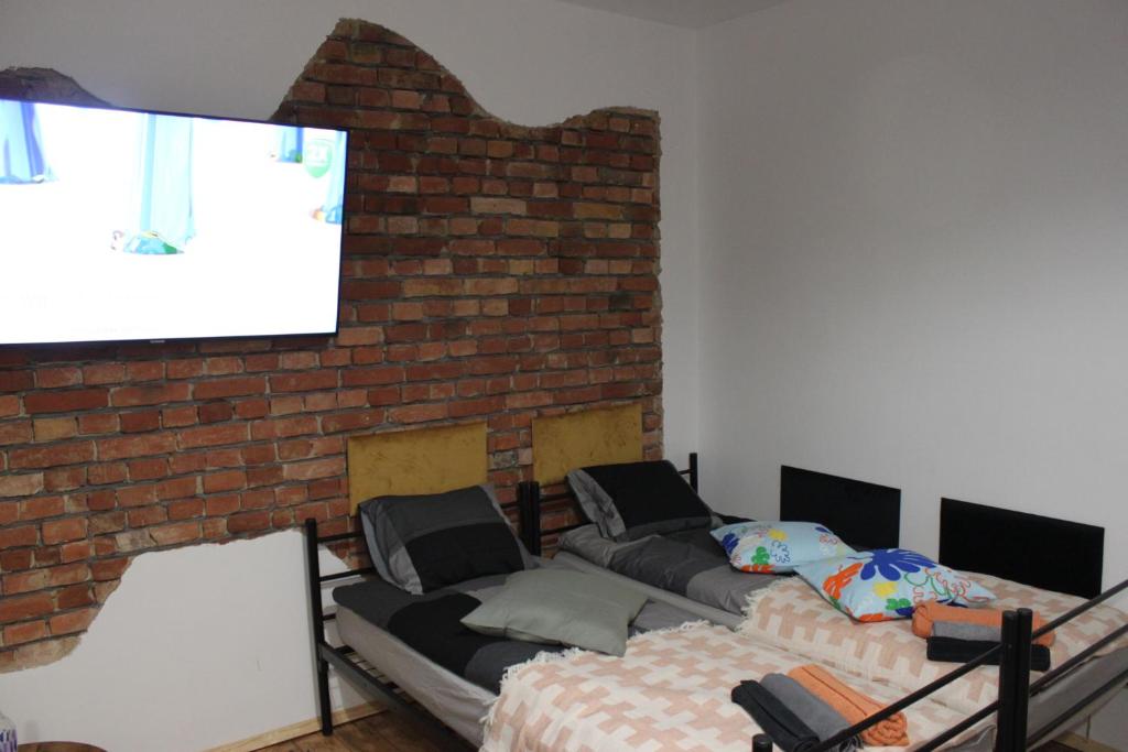a living room with a brick wall and a projection screen at Stargard Apartamenty Centrum in Stargard