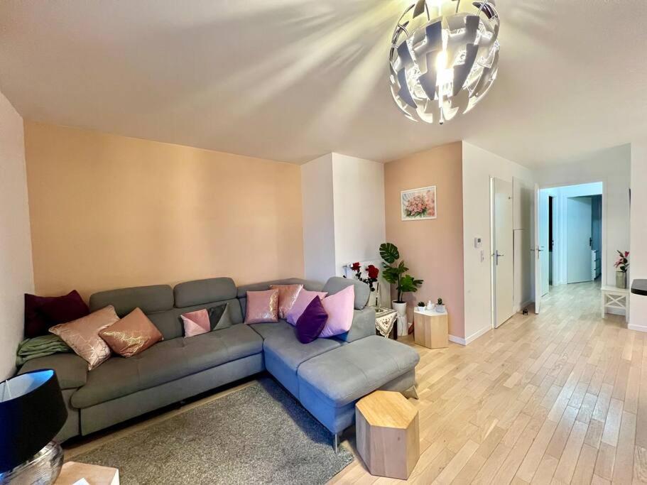- un salon avec un canapé et un lustre dans l'établissement Modern Stylish Secure 2BR Near Paris private Parking, à Rueil-Malmaison