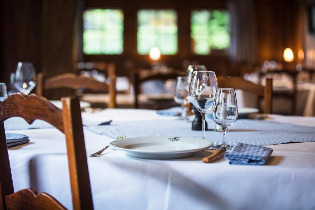 a table with a plate and wine glasses on it at Le Hameau Albert 1er in Chamonix