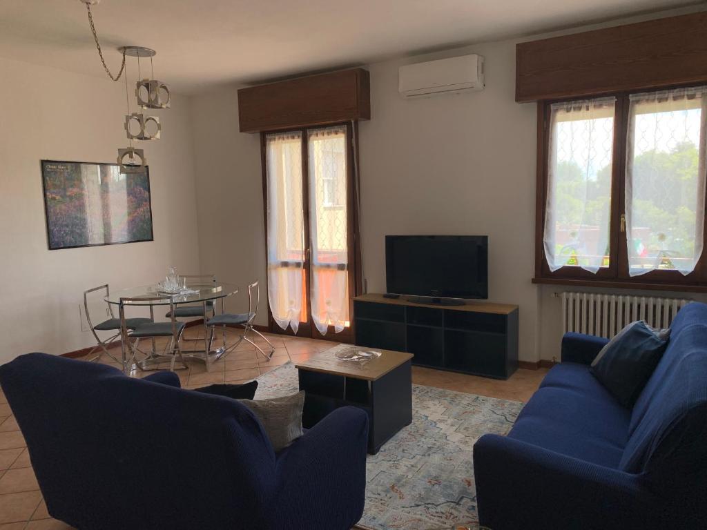 a living room with a blue couch and a tv at Sunshine on the Lake Apartment in Padenghe sul Garda