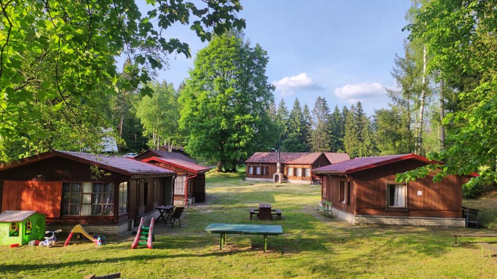 un gruppo di cottage nel bosco con un tavolo di Lesní chaty "Hogo Fogo" a Kytlice