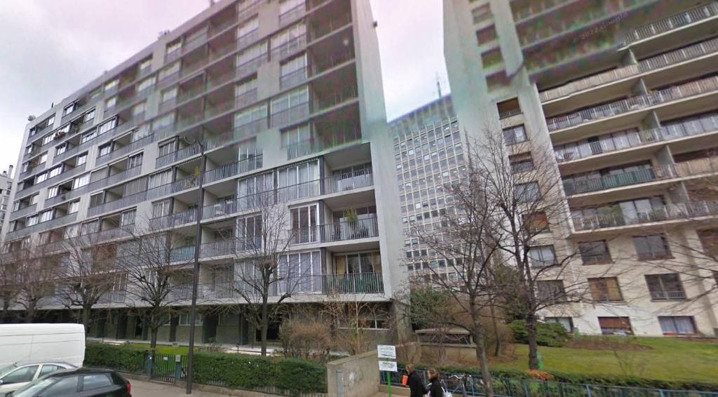 un grand immeuble d'appartements avec des personnes debout devant lui dans l'établissement Prêt à usage & Commodat 13 Finlay RDC- 30 nuitées minimum - Salarié mobilité ou étudiant stagiaire, à Paris