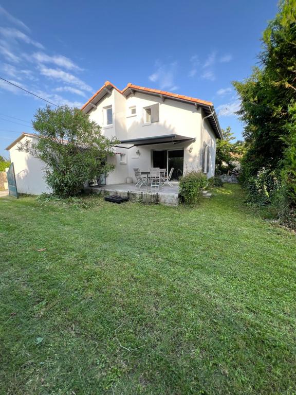 a white house with a grassy yard in front of it at Maison 8 pers à 900 m de la mer au calme in Vaux-sur-Mer