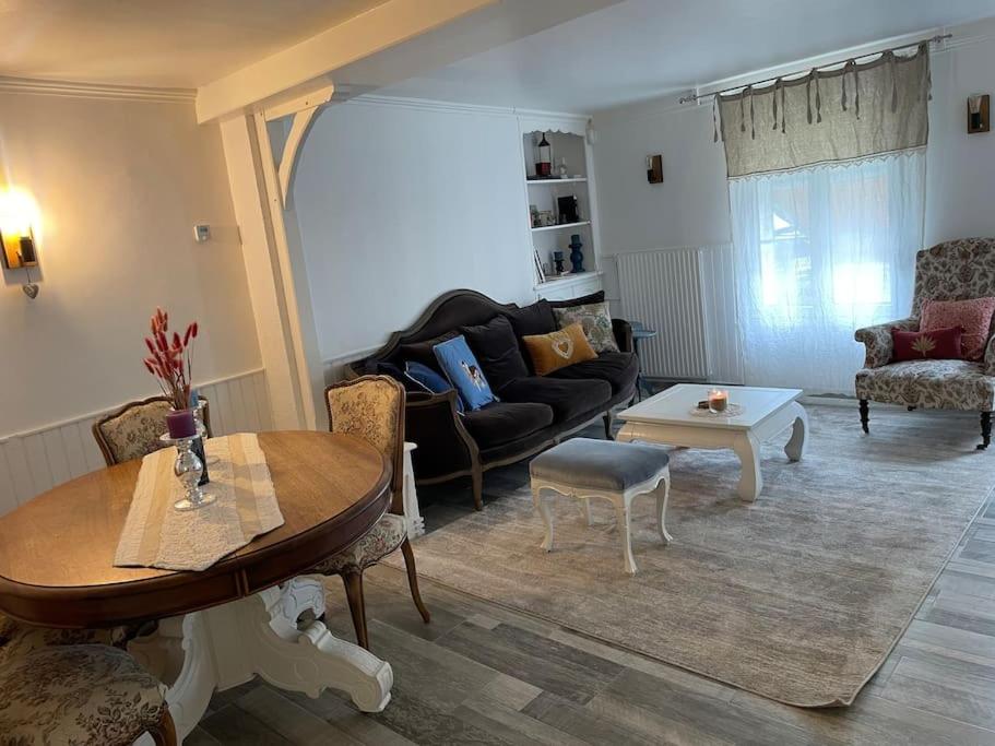 een woonkamer met een bank en een tafel bij Maison face au moulin Giverny in Vernon