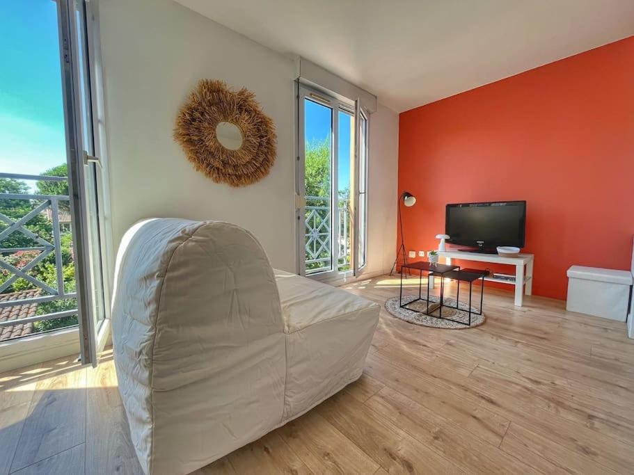 un salon avec un canapé et une télévision à écran plat dans l'établissement Studio refait à neuf avec parking, à Toulouse
