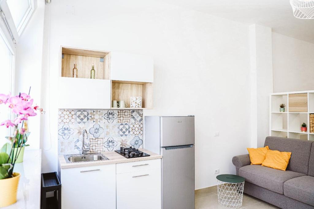 a small kitchen with a couch and a refrigerator at Urban loft in Forio d'Ischia