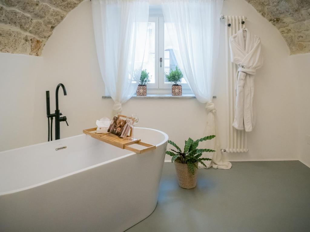 bagno bianco con vasca e finestra di Palazzo Santa Ninfa - Luxury Mansion a Palermo