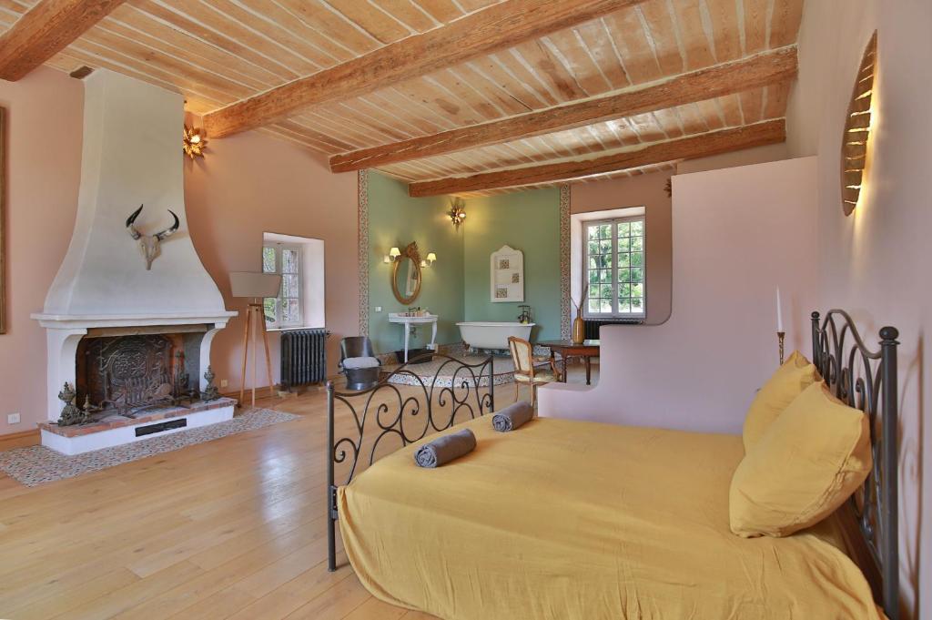 a bedroom with a bed and a fireplace at Chambre d'hôtes Les Temps Heureux in Callian