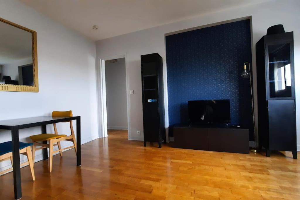 un salon avec une table à manger et une télévision dans l'établissement Appartement 2 pièces tres lumineux, à La Garenne-Colombes