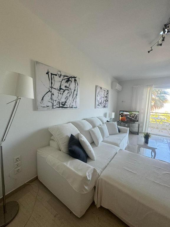 a white bedroom with a large bed and a couch at Artist Home in Porto Rafti