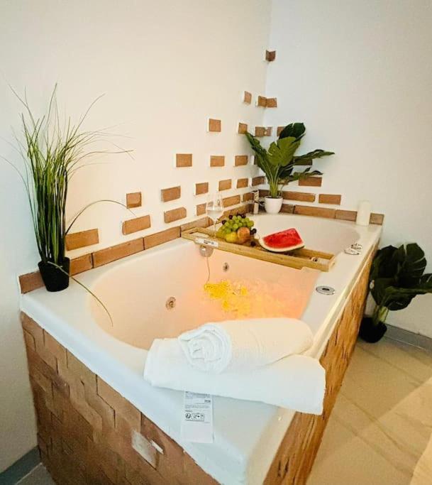 une salle de bain avec baignoire avec serviettes et plantes dans l'établissement Studio Love Jacuzzi, à Marseille