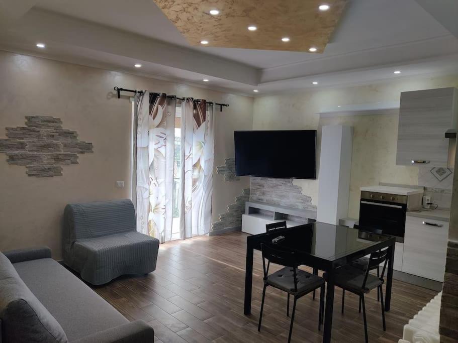 a living room with a couch and a table and a television at Robert's Sweet Station House A in Anguillara Sabazia