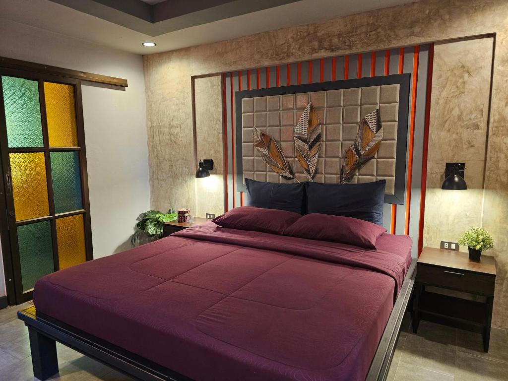 a bedroom with a large bed with a large headboard at Baan Baimai Boutique Room in Phra Nakhon Si Ayutthaya