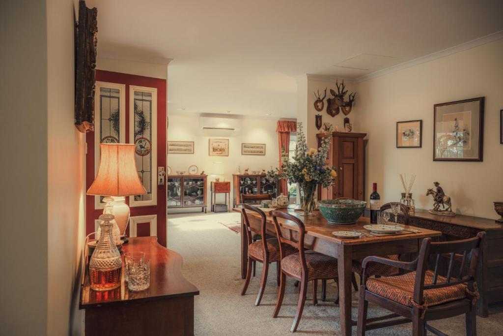 a dining room with a table and chairs at Koolyangarra Cottage Adelaide Hills in Adelaide
