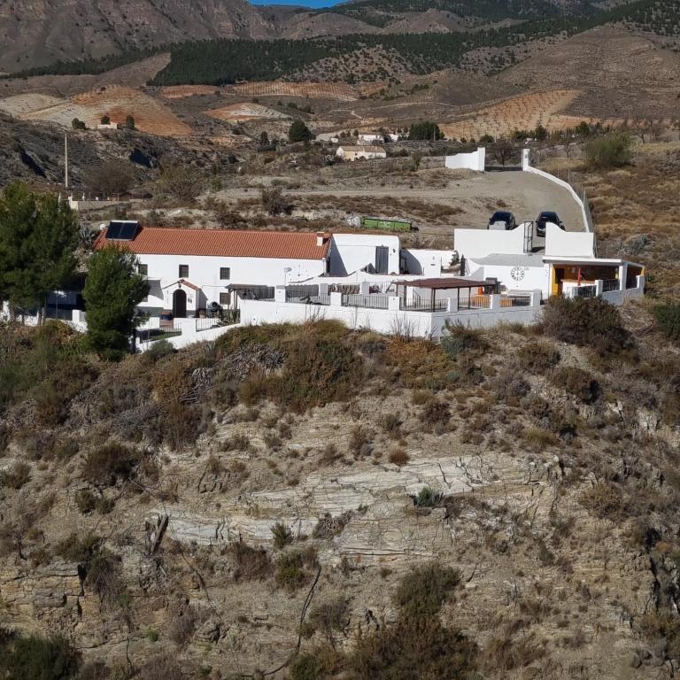 a group of white buildings on a hill in a field at Casa Naturista Con Vistas in Oria