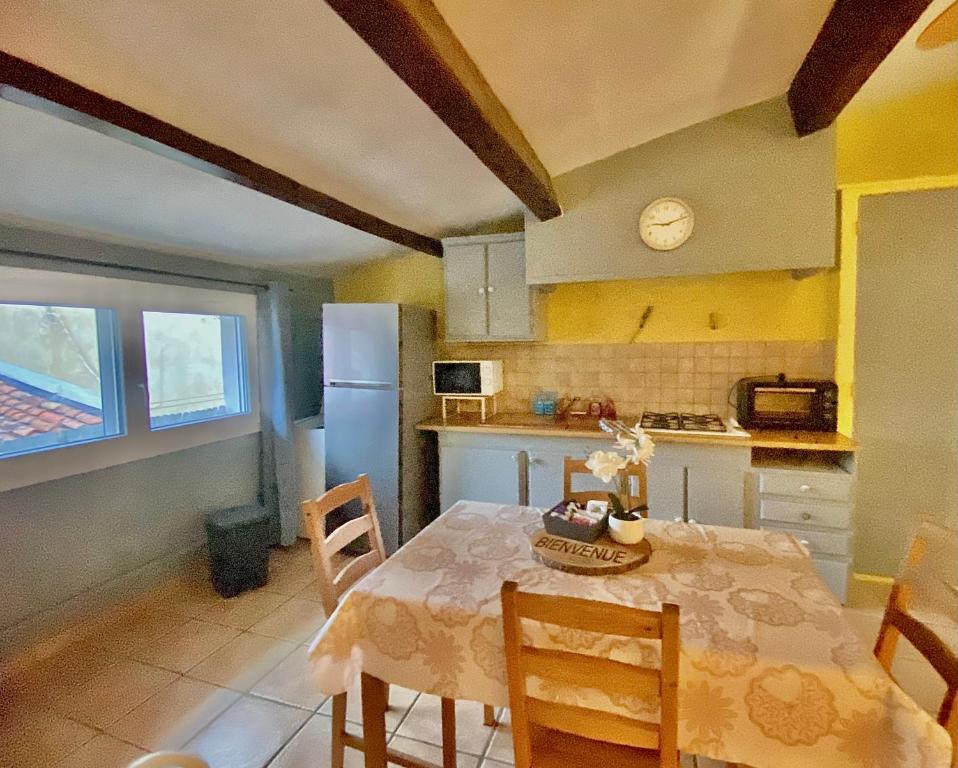 une cuisine avec une table, des chaises et un réfrigérateur dans l'établissement Canolle Charme Climatisé 1mn du port by LaConciergerie13, à La Ciotat