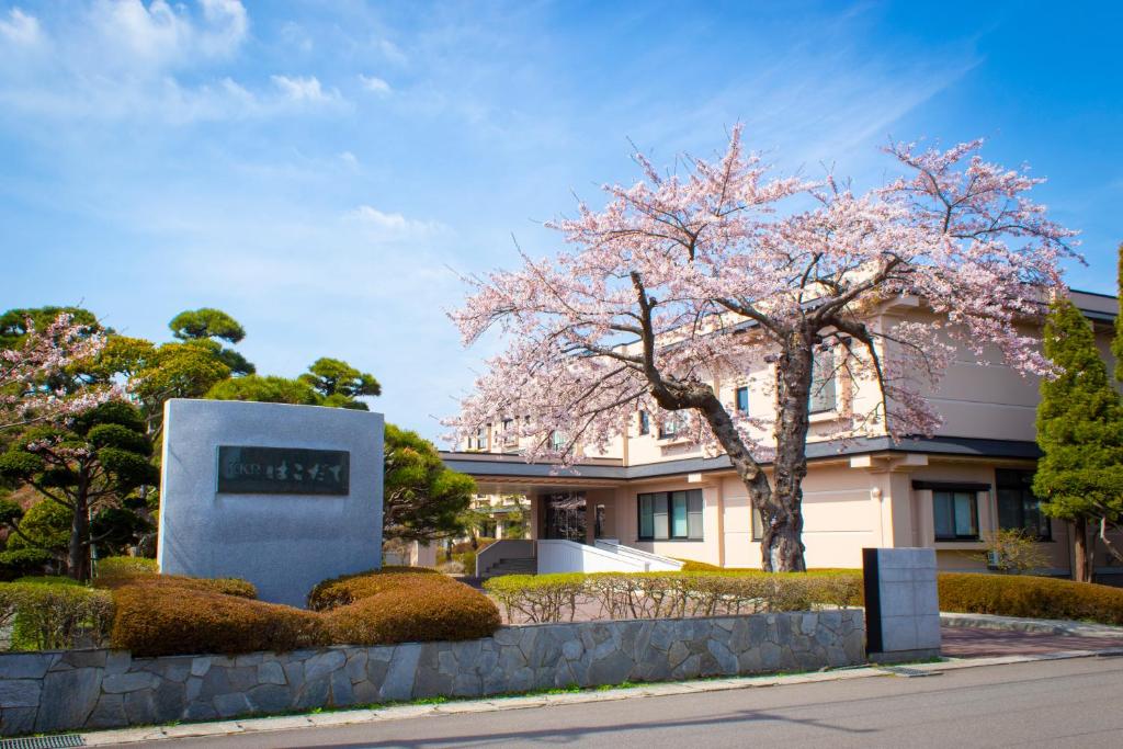 函館市にあるKKRhakodateの建物の前に花の咲いた木がある建物
