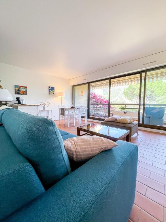 un salon avec un canapé bleu et une table dans l'établissement Le Naïs - Proche centre - Parking - Wifi, à Cassis