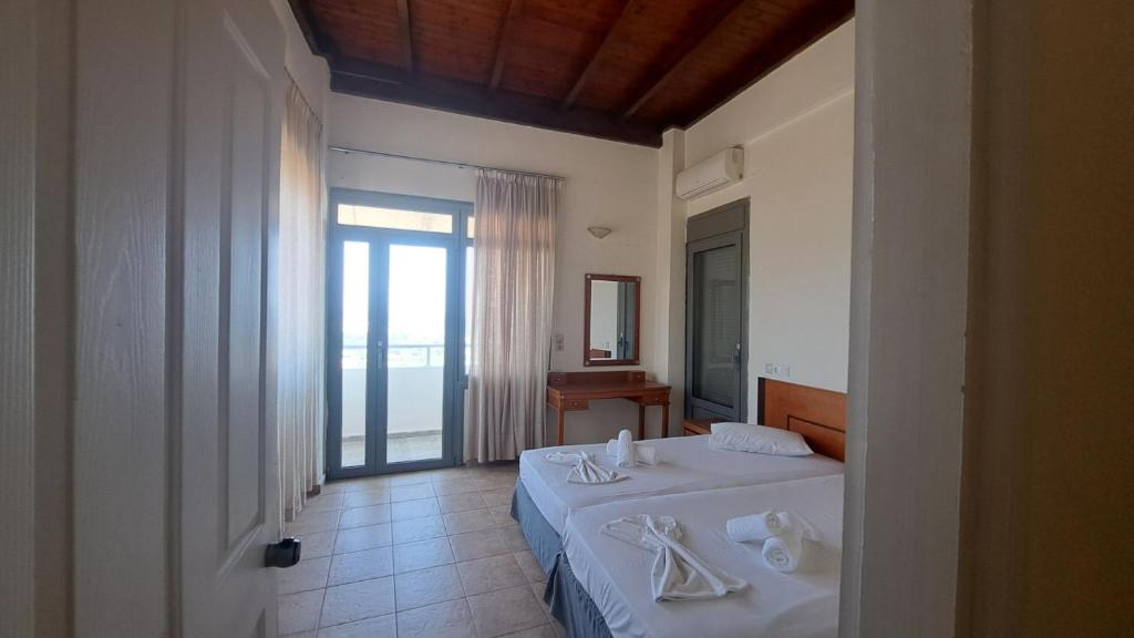 sypialnia z łóżkiem oraz łazienka z oknem w obiekcie Hercules Hills Sea View Villas w mieście Kos