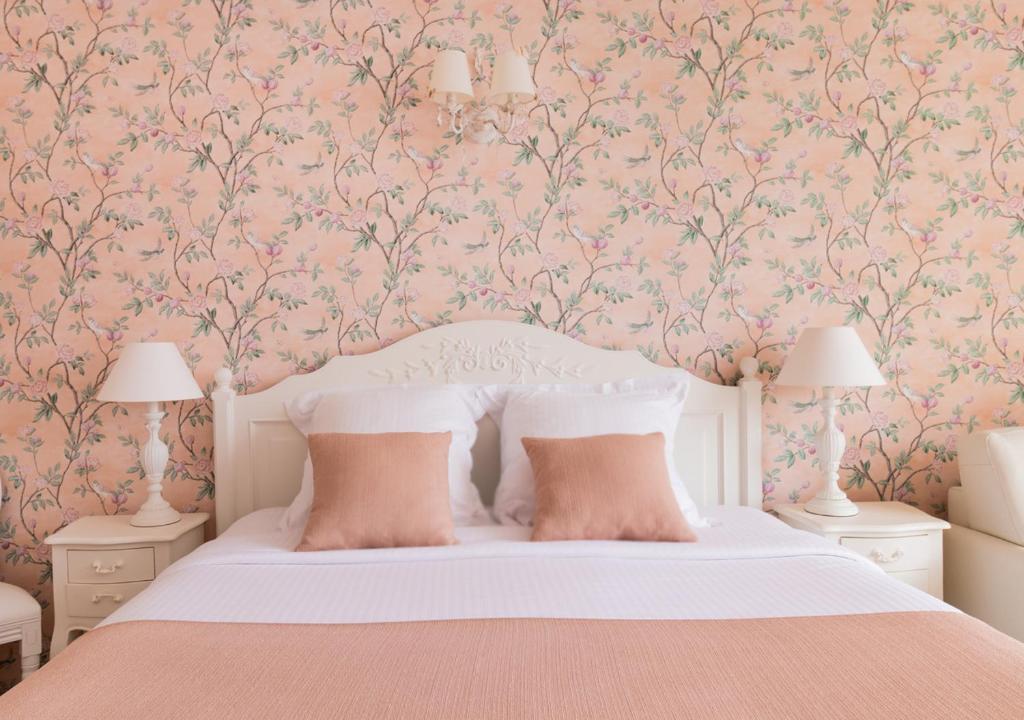 カンヌにあるCannes Imperial Croisette Palais Miramarのピンクの花の壁紙を用いたベッドルーム1室