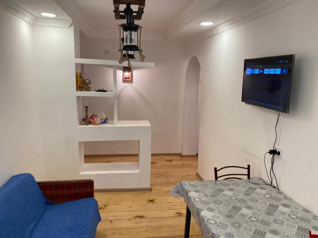 メスティアにあるAPARTMENT in MESTIAのリビングルーム(青いソファ、壁掛けテレビ付)