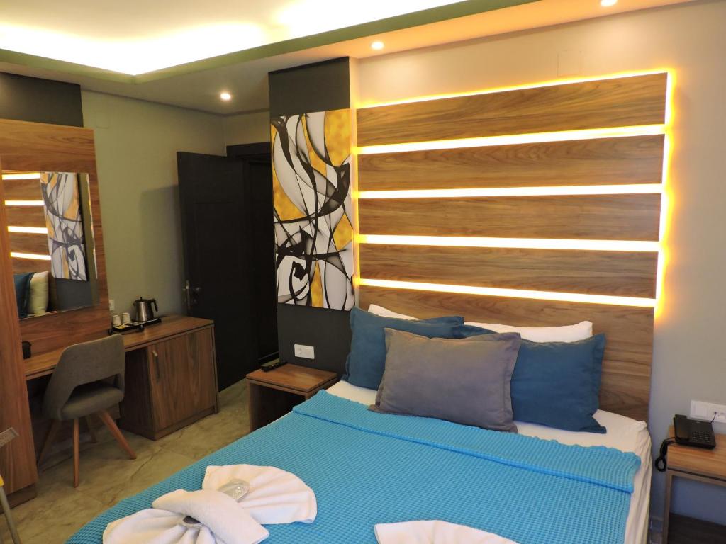 a bedroom with a blue bed with a wooden headboard at Başar hotel in Erdemli