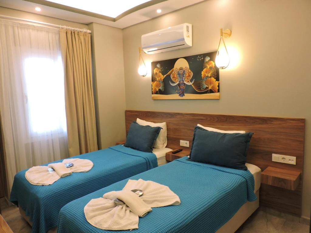 two beds in a hotel room with towels on them at Başar hotel in Erdemli