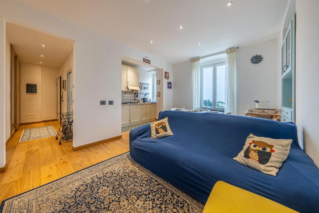 een woonkamer met een blauwe bank en een keuken bij A CASA DEL BOSCHETTO Vista, Relax e Comfort in Camogli