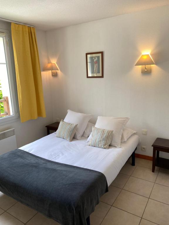 een slaapkamer met een groot bed met twee kussens bij Vue Sur Green in Levernois