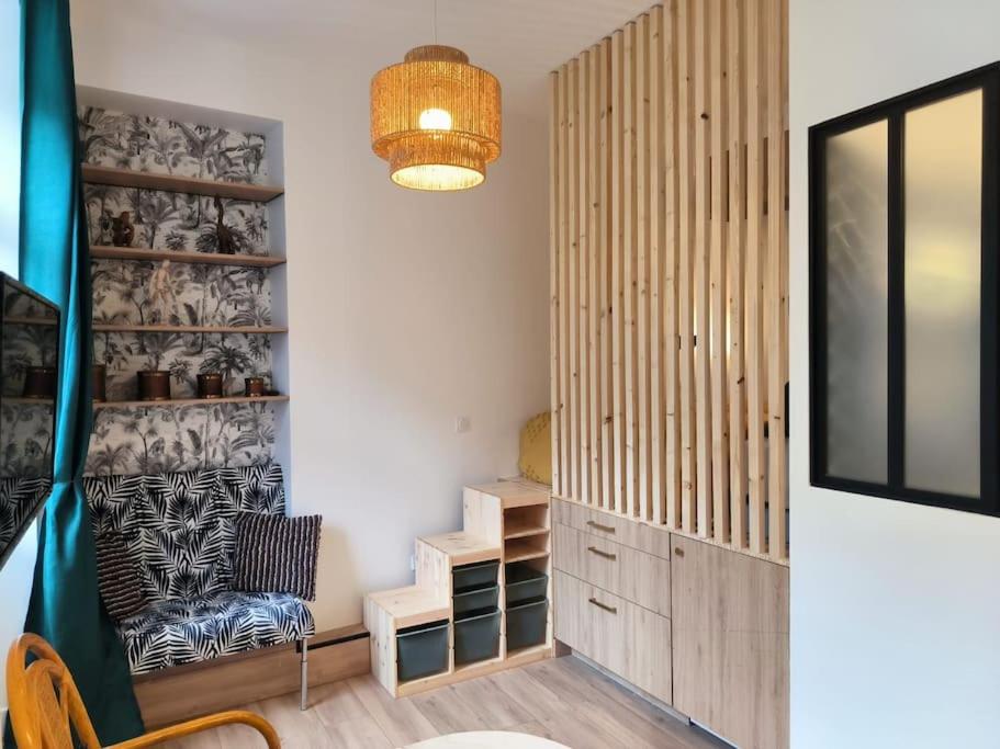 Un comedor con una silla y un televisor. en Studio à 100 m de la plage PIQUOT 44, en Granville