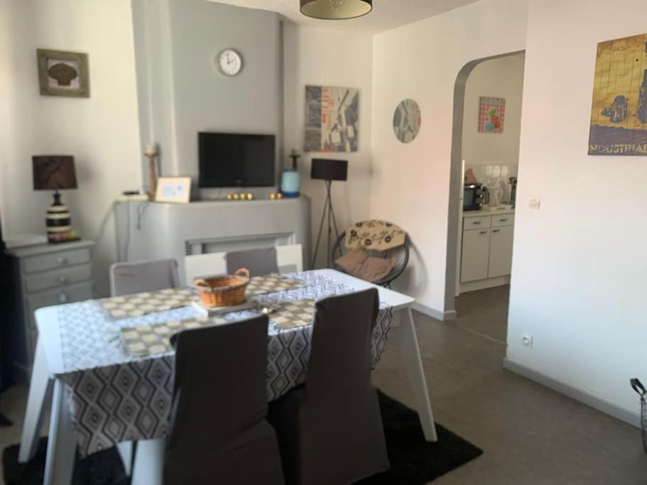 une salle à manger avec une table avec des chaises et une télévision dans l'établissement Charmant appartement proche de la rue Saint Jean, à Le Touquet-Paris-Plage