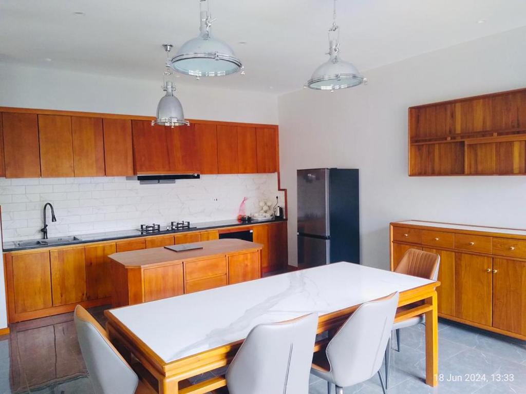 The Reserve Bed and Breakfast في هراري: مطبخ مع خزائن خشبية وطاولة وكراسي