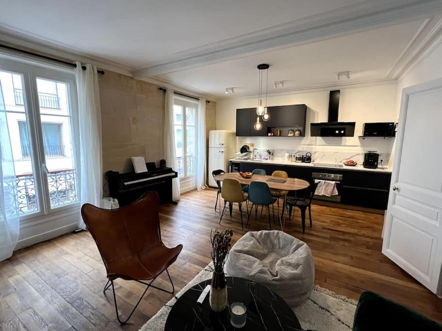 un salon avec une table et des chaises et une cuisine dans l'établissement Design flat for 4 people Paris 18 close to Montmartre, à Paris