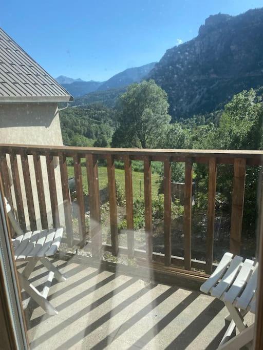 d'un balcon avec deux chaises et une vue sur la montagne. dans l'établissement logement appartement dansMaison de pays, à Saint-Martin-de-Queyrières