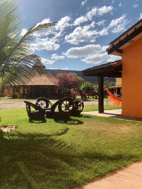 a group of benches in the grass next to a building at Pousada e restaurante Jardim do Cerrado MT in Nobres