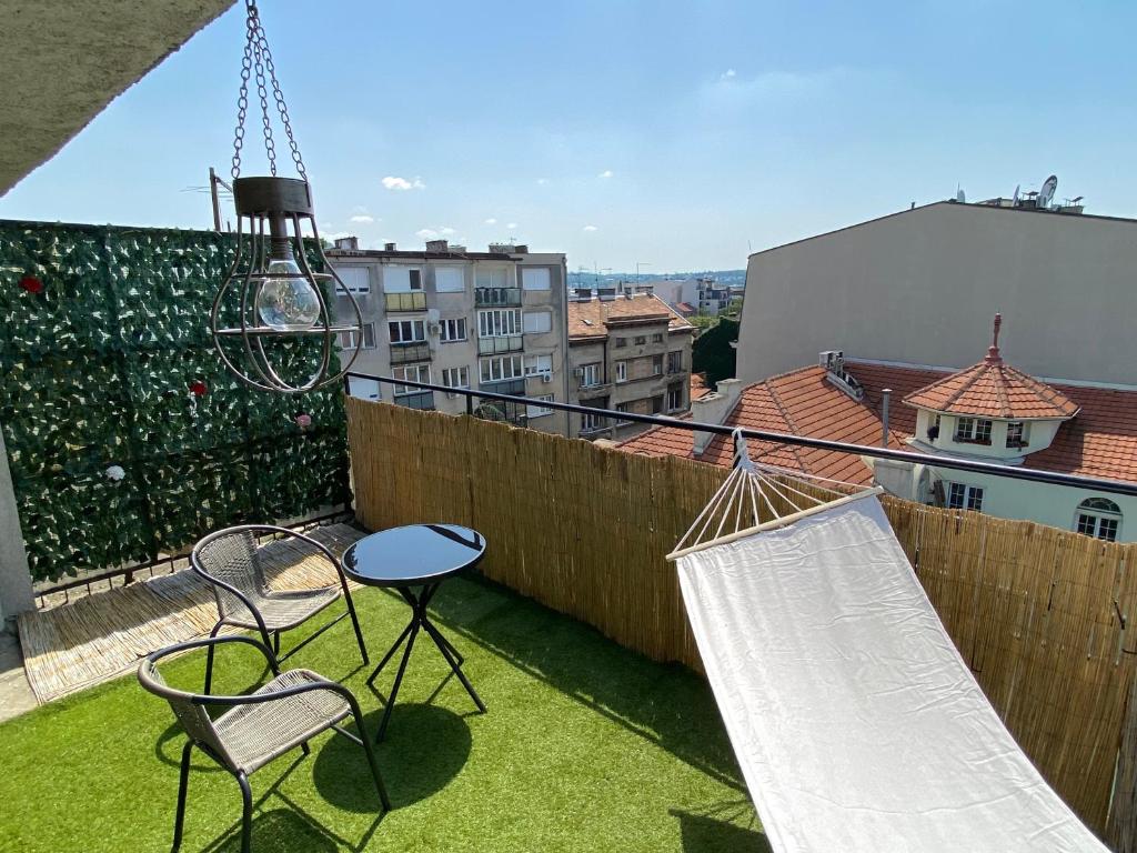 a patio with chairs and hammocks on a balcony at Panorama Royal Vračar in Vračar (historical)