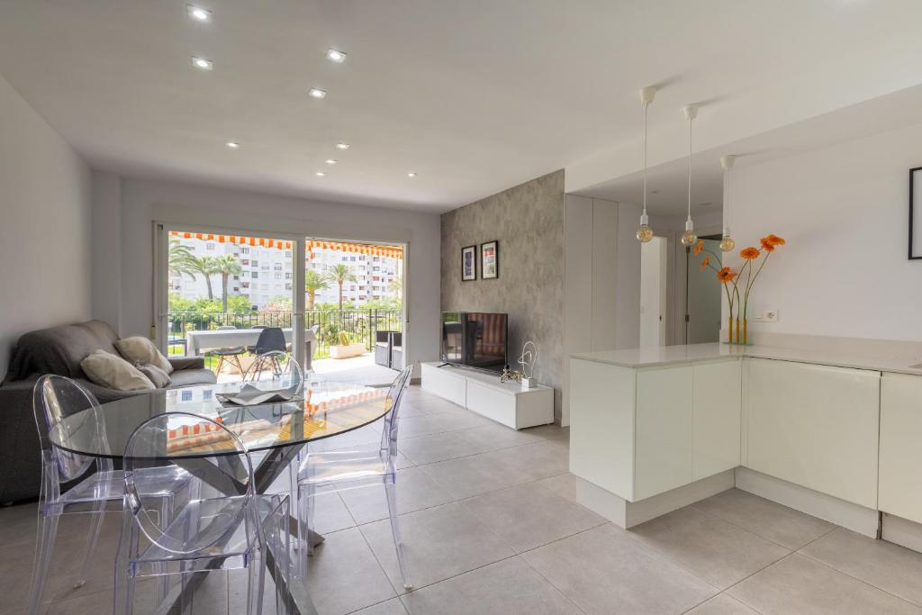 a kitchen and living room with a glass table at Residencia de Lujo Frente al Mar in Playa de Gandia