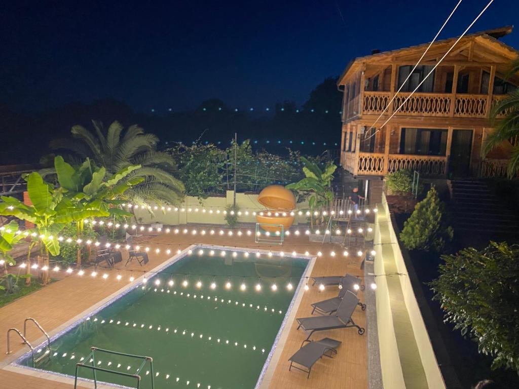 a swimming pool with lights next to a building at Kvirike Gardens in Kobuleti