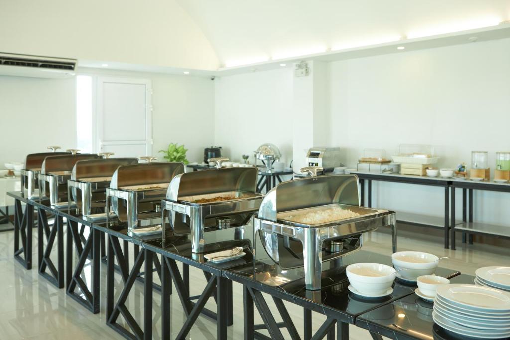 A bright breakfast buffet with stainless-steel serving trays, plates and bowls.