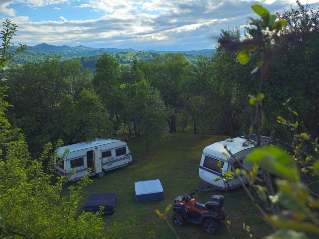 two rvs and a jeep parked in a field at La Rulote in Căpăţîneni-Ungureni