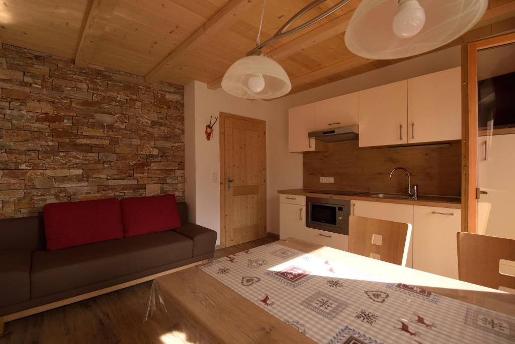 a living room with a couch and a kitchen at Pircherhof in San Candido