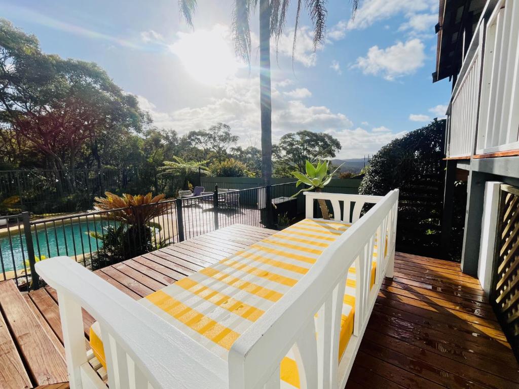 a white bench sitting on a deck next to a pool at Central Coast Getaway 4B Family Holiday Home in Umina