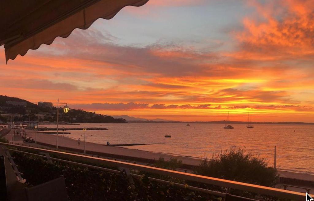 - un coucher de soleil sur une plage avec une masse d'eau dans l'établissement Luxueux appartement front de mer, à Cannes