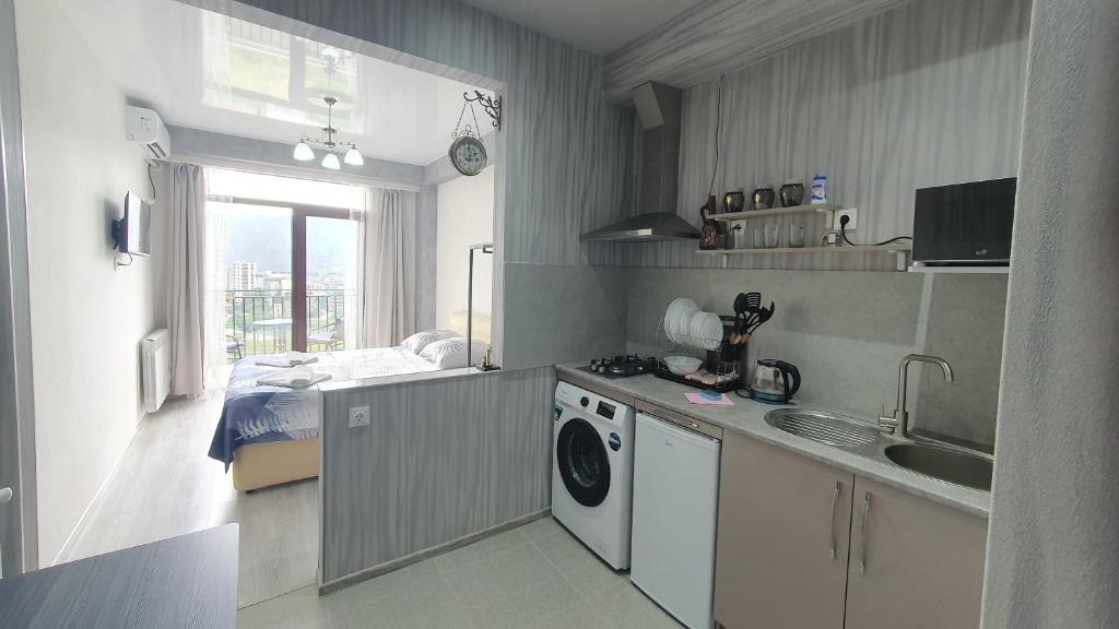una cocina con fregadero y lavadora en GeoFamilyNest, en Tiflis