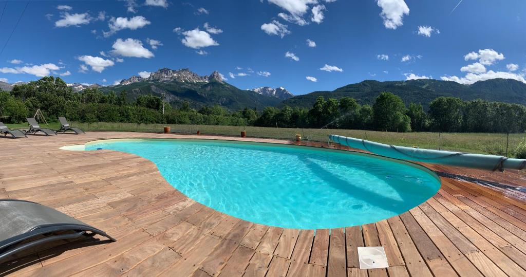 une piscine avec des montagnes en arrière-plan dans l'établissement L'Escale en Ubaye, à Saint-Pons