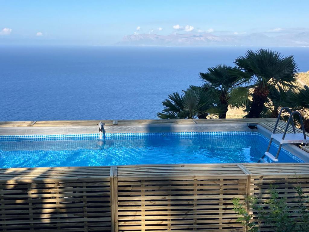 a swimming pool with the ocean in the background at Baglio La Luna - B&B in San Vito lo Capo