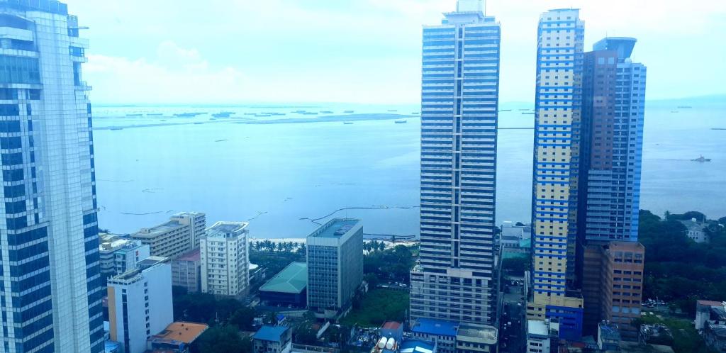 a view of a city with tall buildings and a body of water at 8 Adriatico Manila Condotel Sea View Corner Unit Near St Lukes Clinic in Manila
