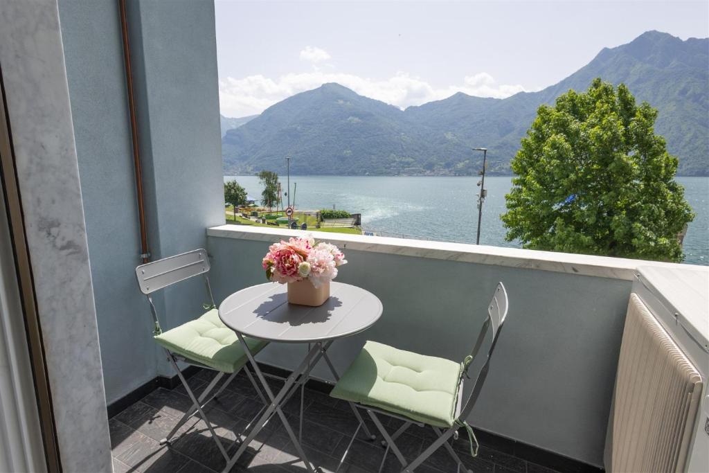 a table and chairs on a balcony with a view of the water at IseoLakeRental - Fantasy Lake in Castro